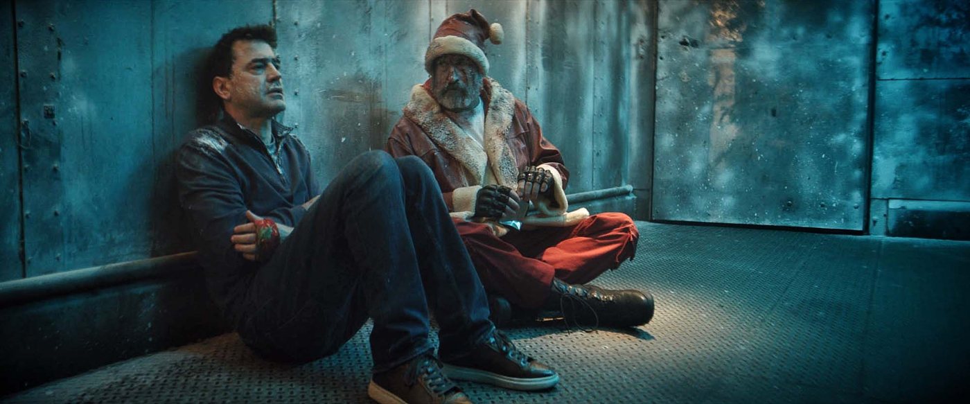 Mark and Santa sitting against a frosted metal wall